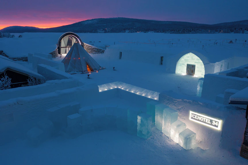 A frozen northern river with timber cabins along the far bank